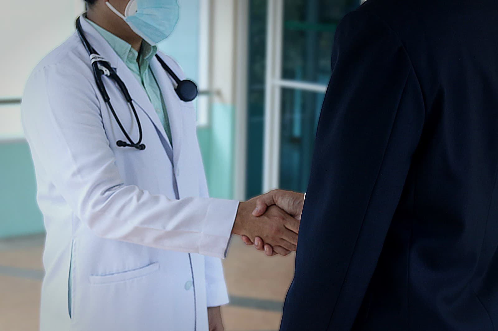 A doctor shaking hands with a patient
