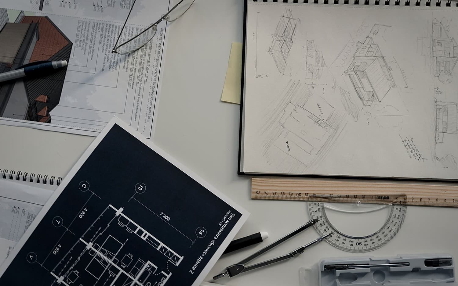 Construction drawings, a floor plan and drafting tools spread across a desk