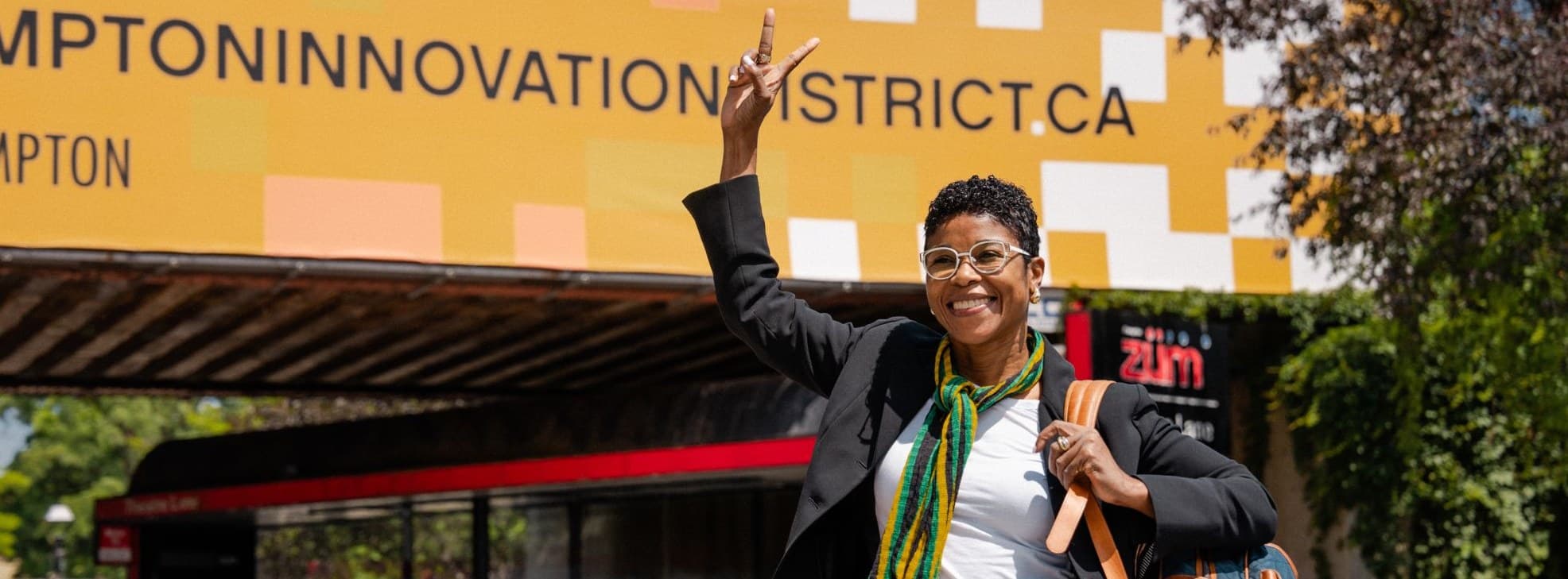 A woman celebrating under the Brampton Innovation District sign
