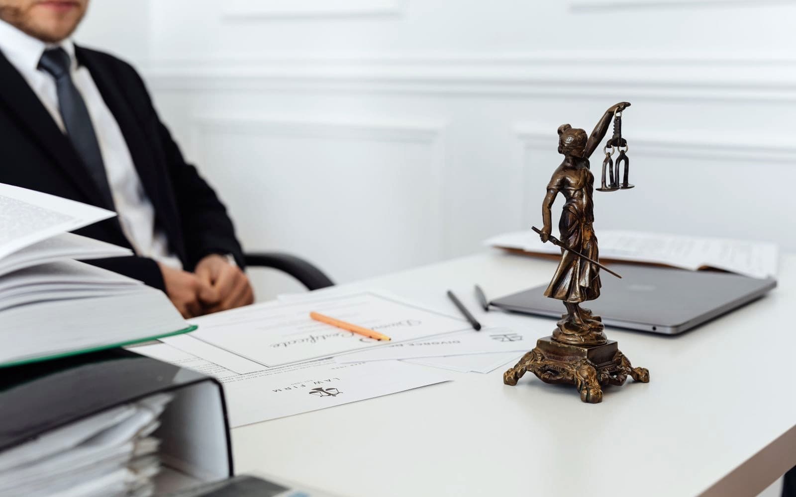 Scales of justice on a desk beside legal papers